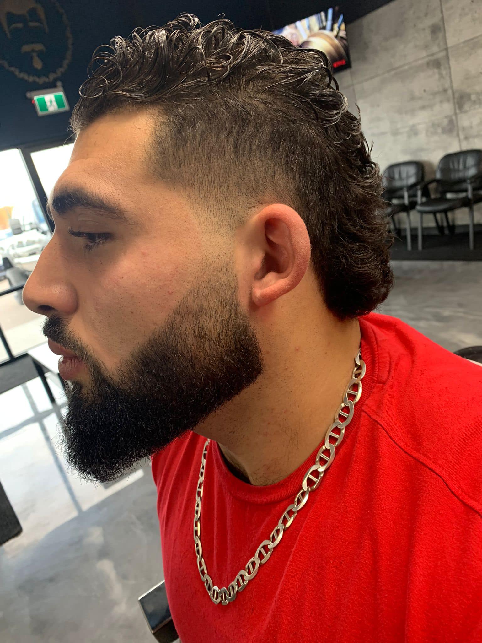 Professional haircut with curly hair on top, faded sides, and well-groomed beard